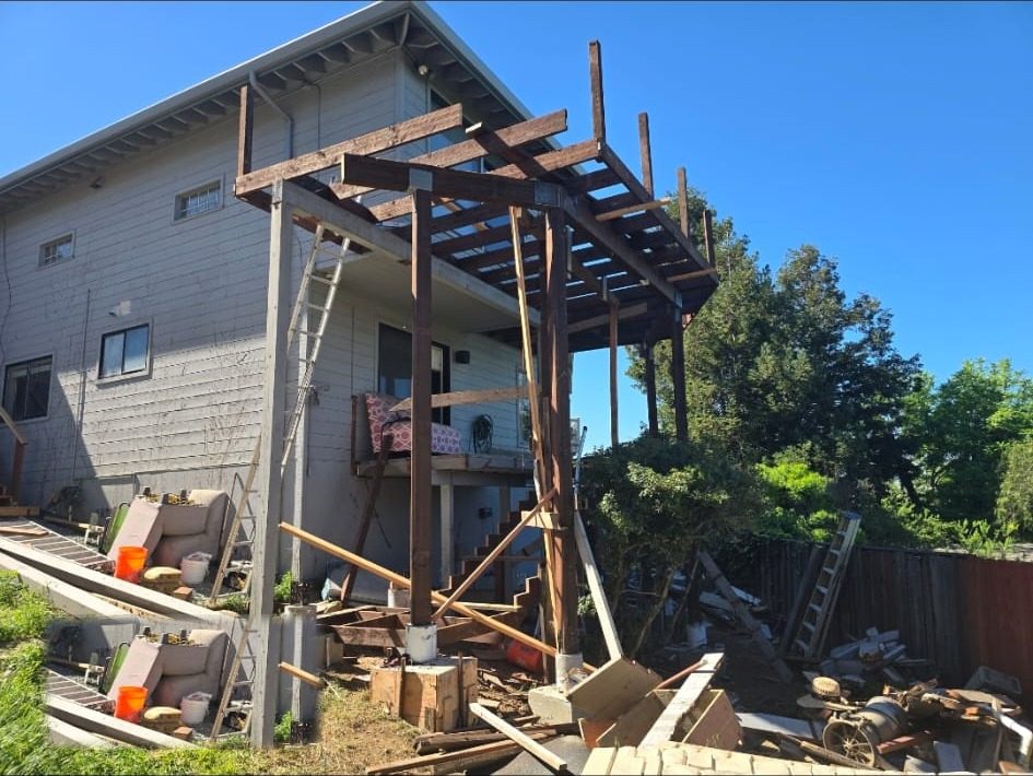 Two-story deck mid-rebuild, old deck torn out and new framing going up